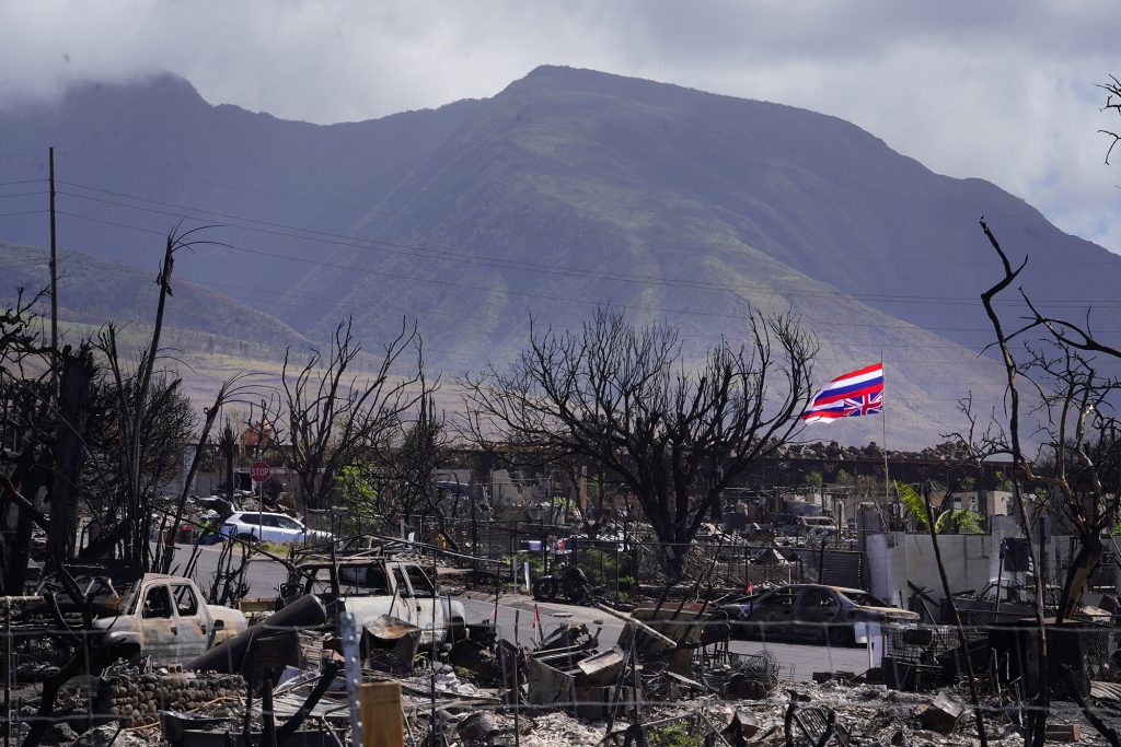 A signal of distress, the upside-down Hawaii State flag flies above the ashes of a destroyed Lahaina neighborhood  Thursday, Nov. 9, 2023. Lahaina town was devastated by the Aug. 8. fire. Tourism reopened in West Maui on Nov. 1. (Kevin Fujii/Civil Beat/2023)