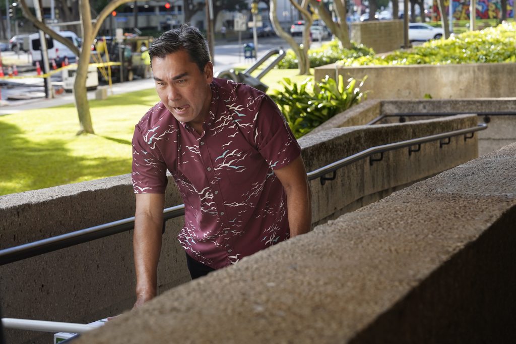 Chad Michael McDonald pushes a cart of documents to entrance of the Prince Jonah Kūhiō Kalanianaʻole Federal Building and United States Courthouse for the Kaneshiro corruption trial Thursday, April 4, 2024, in Honolulu. (Kevin Fujii/Civil Beat/2024)