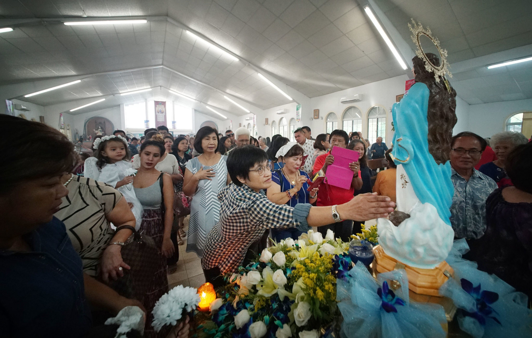 Parishioners pay their respects during mass/celebration held at Assumption of Our Lady in Piti, Guam.