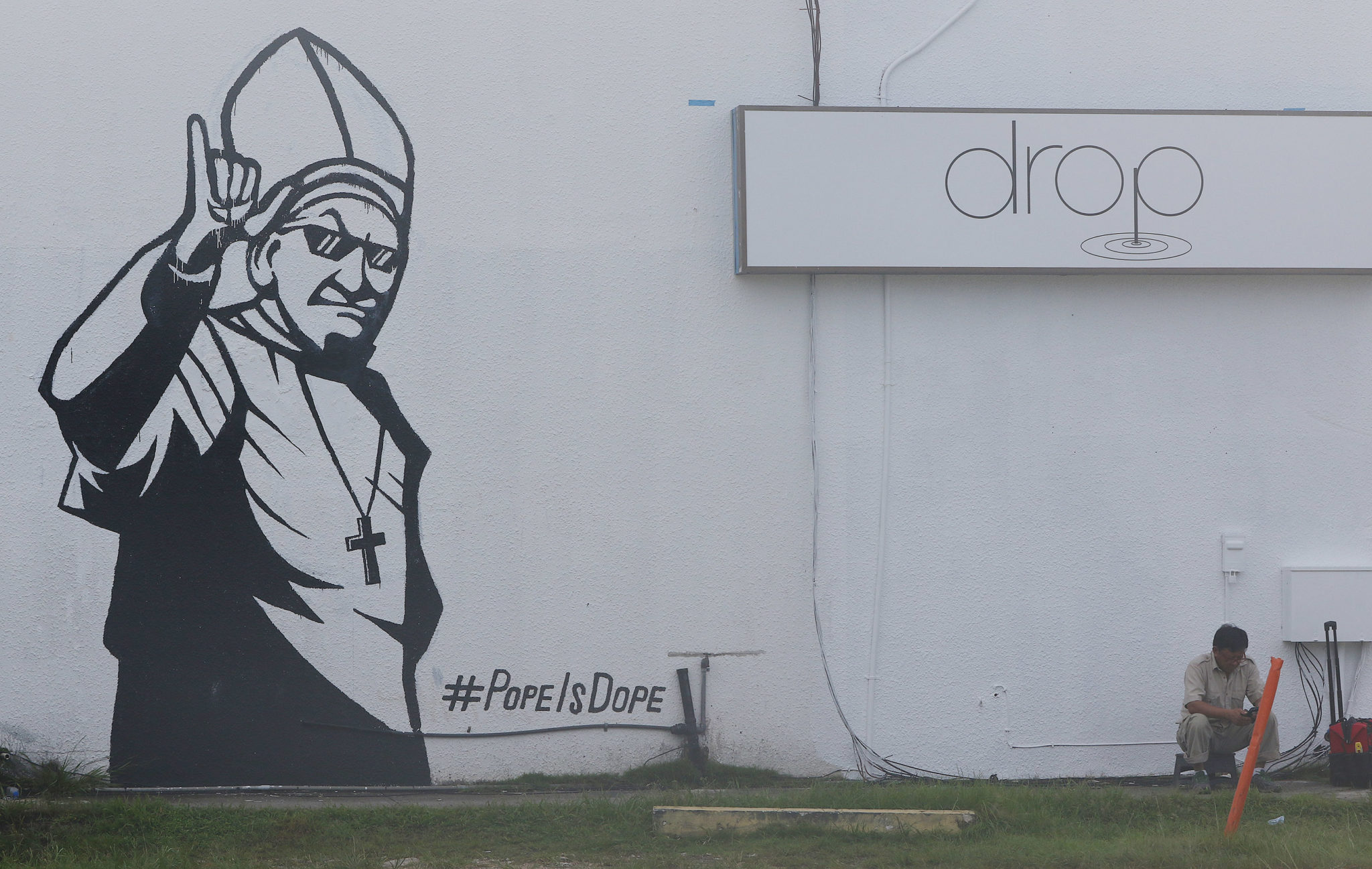 Guam Tumon painting Pope is Dope on side of building.